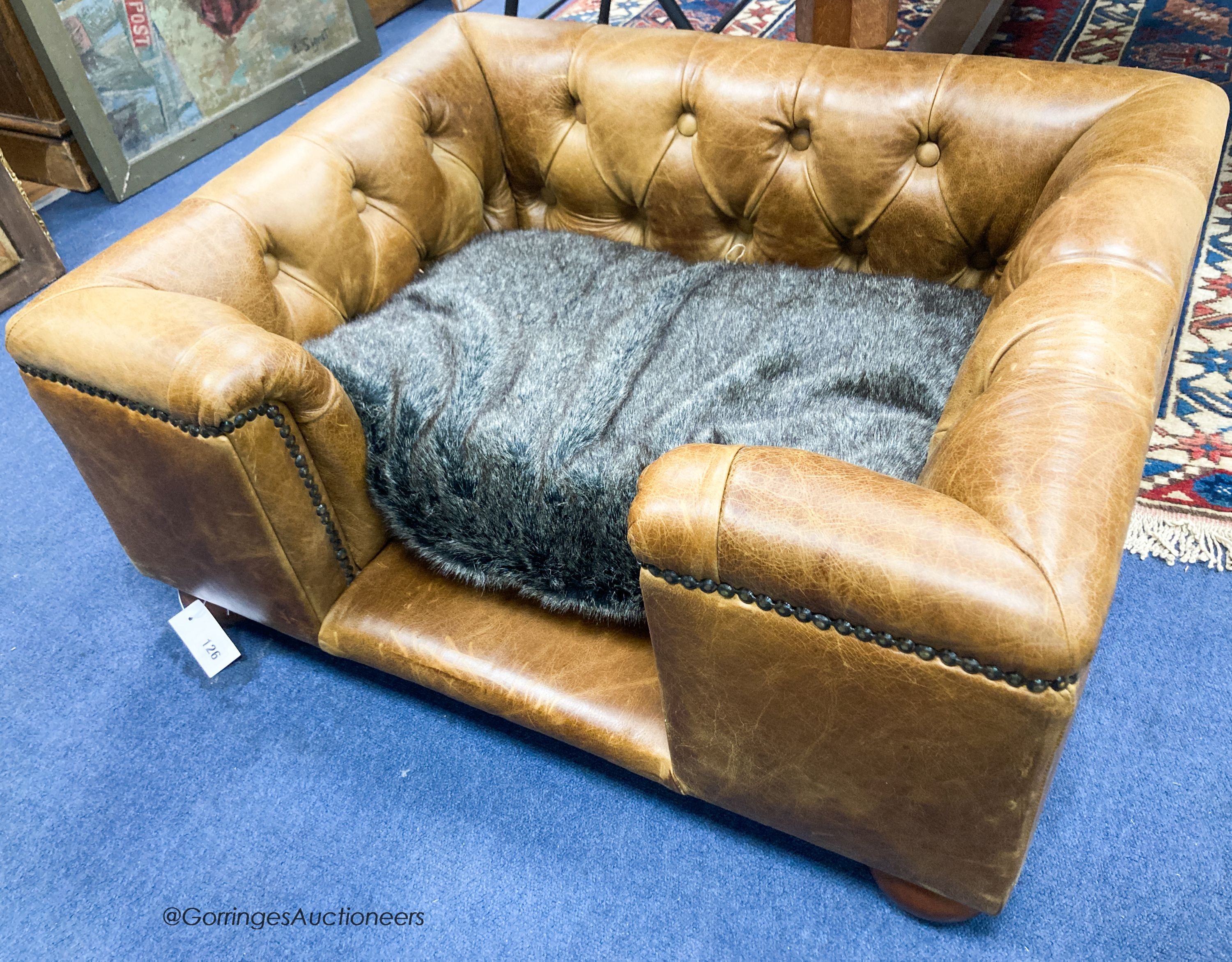 An Italian buttoned tan leather dog's bed with loose cushion, width 84cm, depth 68cm, height 36cm